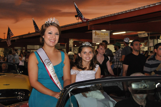 two girls with crowns sitting in convertible car