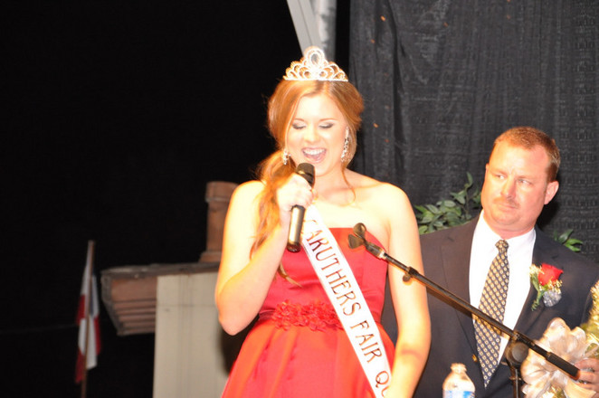 girl with sash and crown speaking into microphone