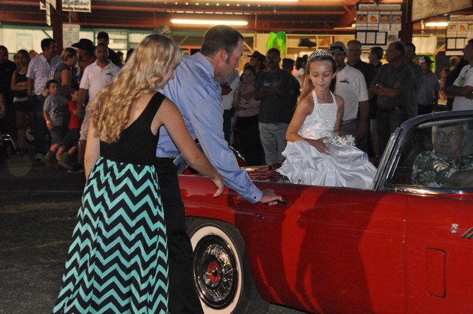 man and woman opening door for young girl in classic convertible car