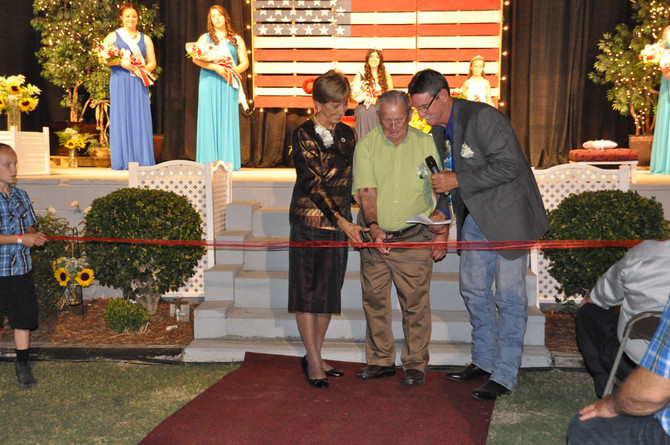 man and woman cutting ribbon with scissors
