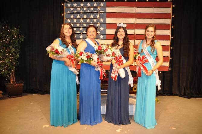 4 girls with sashes and bouquet of flowers standing in front of american flag