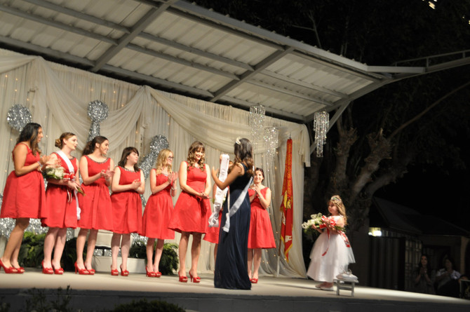 girl placing sash on another girl on stage