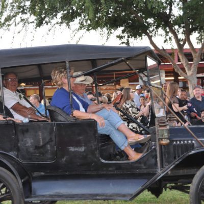 four people driving in old fashioned car