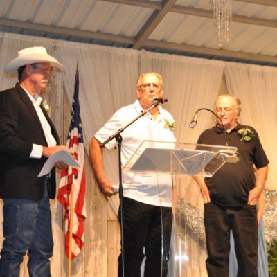 three men standing in front of podium