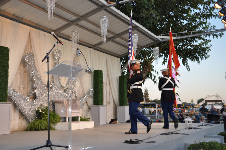 two men in uniform with flags walking on stage