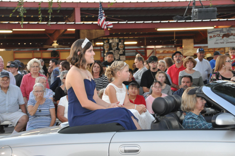 side view of girl with crown sitting in convertible car