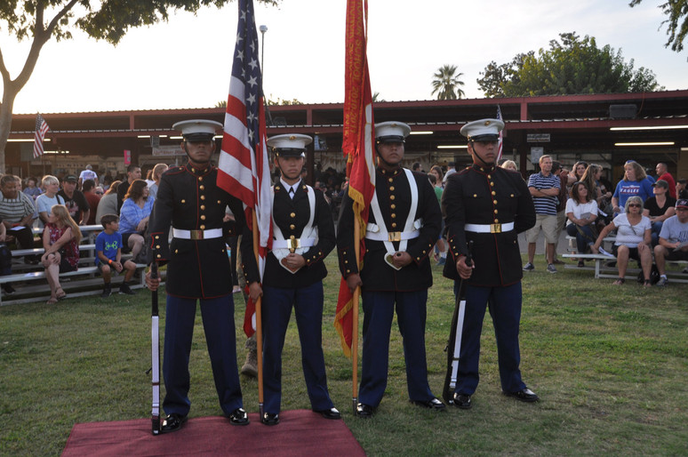 four men in uniform holding american flag