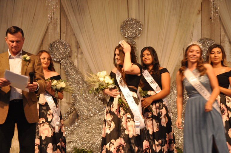 girls on stage with sashes and bouquet of flowers
