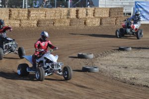 three racers driving atvs on the track