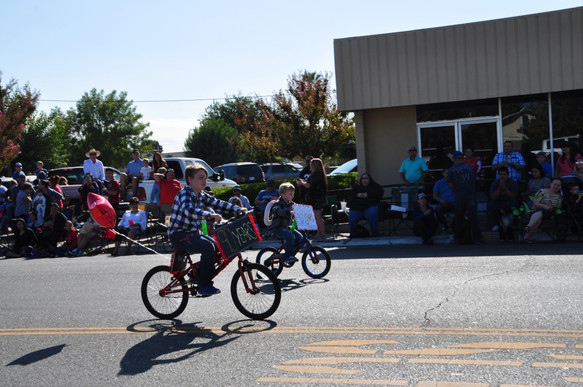 two children riding bicycles in the parade