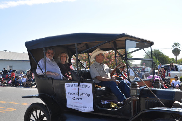 grand marshals sitting in old fashioned car in the parade