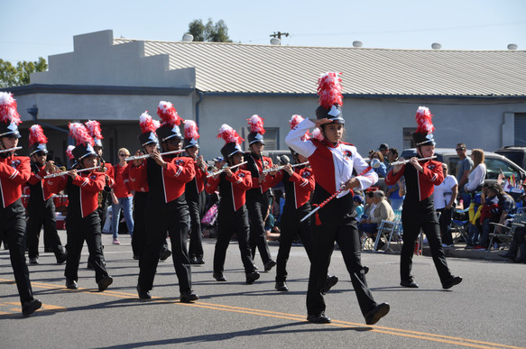 marching band flute players playing and marching
