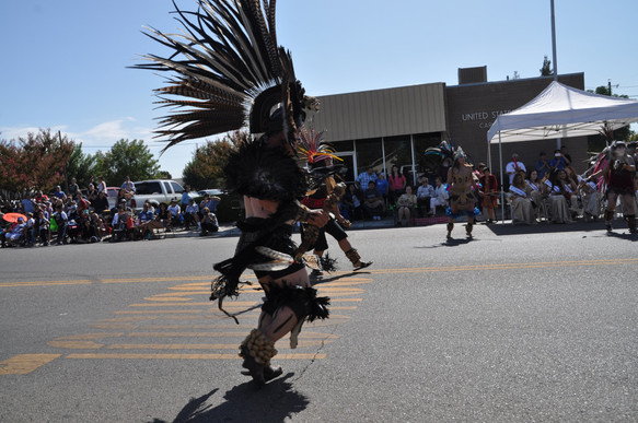 people in tribal costumes dancing in the parade